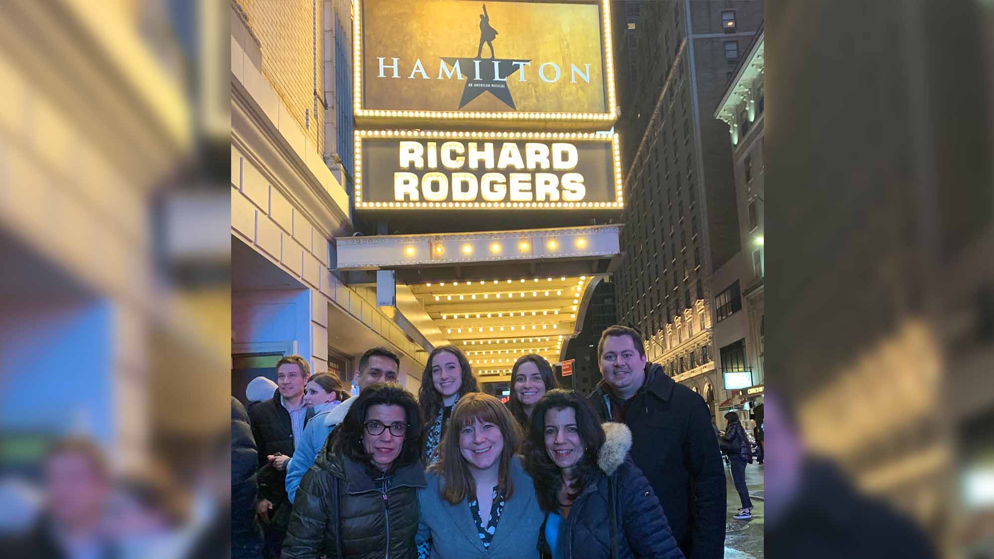 The Clyde Paul team at the Richard Rodgers Theatre posing with the Hamilton sign.