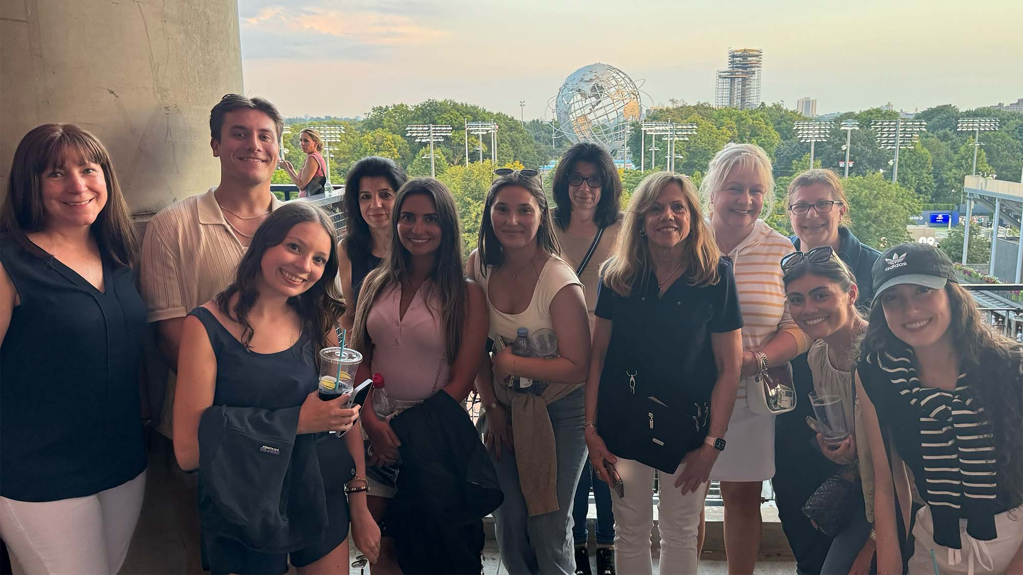 Clyde Paul team posing with a view of the Unisphere