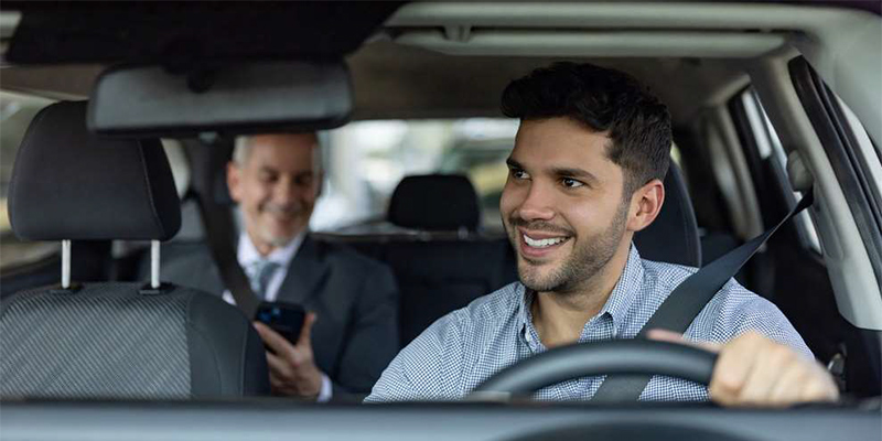 A photo of a driver and passenger in a ride-share vehicle.