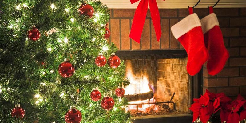 A cozy fireplace scene with a Christmas tree and stockings.