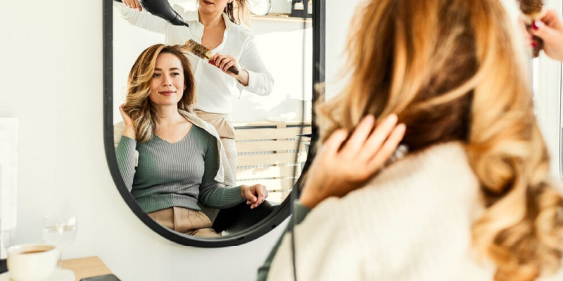 Hair stylist applying color to a client’s hair in a modern salon, emphasizing salon insurance coverage for beauty professionals and small business protection